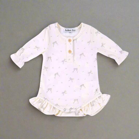 PRODUCT DESCRIPTION
Crafted from luxuriously soft 100% organic cotton, the vintage inspired onesie is thoughtfully designed for your little one’s earliest days. This nostalgic piece features an exclusive Arthur Ave floral print in muted vintage tones, set against a soft milk-white base. Delicate frill detailing at the legs, a classic, button neckline and contrasting trim at the neck and armholes lend a refined finish. With a gentle envelope neck and snap closures at the gusset.