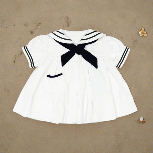 Absolutely fabulous! Just a couple of words you can use to describe this gorgeous dress! Beautifully made from vintage fabric it has hand-created applique around the sailor inspired collar and short sleeve edges in contrasting navy. A button neck, gathered yolk, pocket and tie complete cute dress. From Arthur Ave by Natasha Dwyer of Sydney,