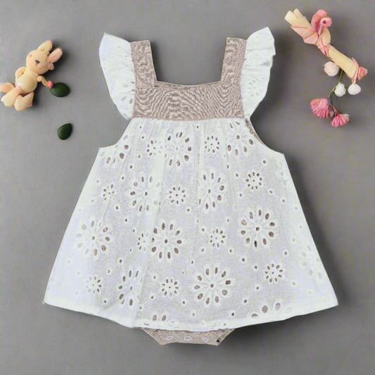 PRODUCT DESCRIPTION  From the Neutral Love Collection by Arthur Ave this mid-taupe colour playsuit has a white broderie anglaise overlay, tucks across the chest, gathered cap sleeves and is utterly adorable! Buttons down the back, domes at the crutch and elasticated leg holes make it easy to dress your little one. We love it and so will you!  MATERIALS  100% Cotton  CARE INSTRUCTIONS  Please read garment labels