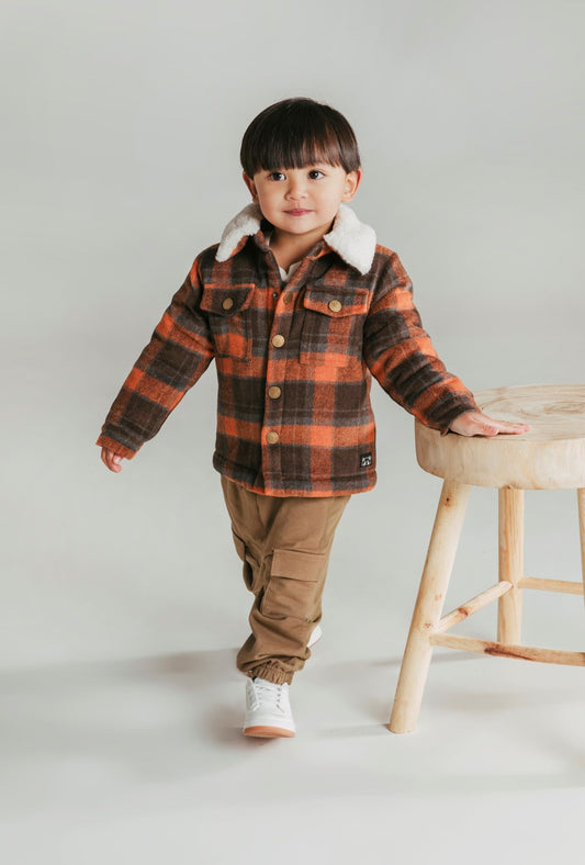 This is the coolest winter coat for your little one. Made from a check fabric outer and a fluffy sherpa style fabric inner for extra snuggle factor. Top flap pockets and domes complete this oh so stylish jacket. By Animal Crackers.