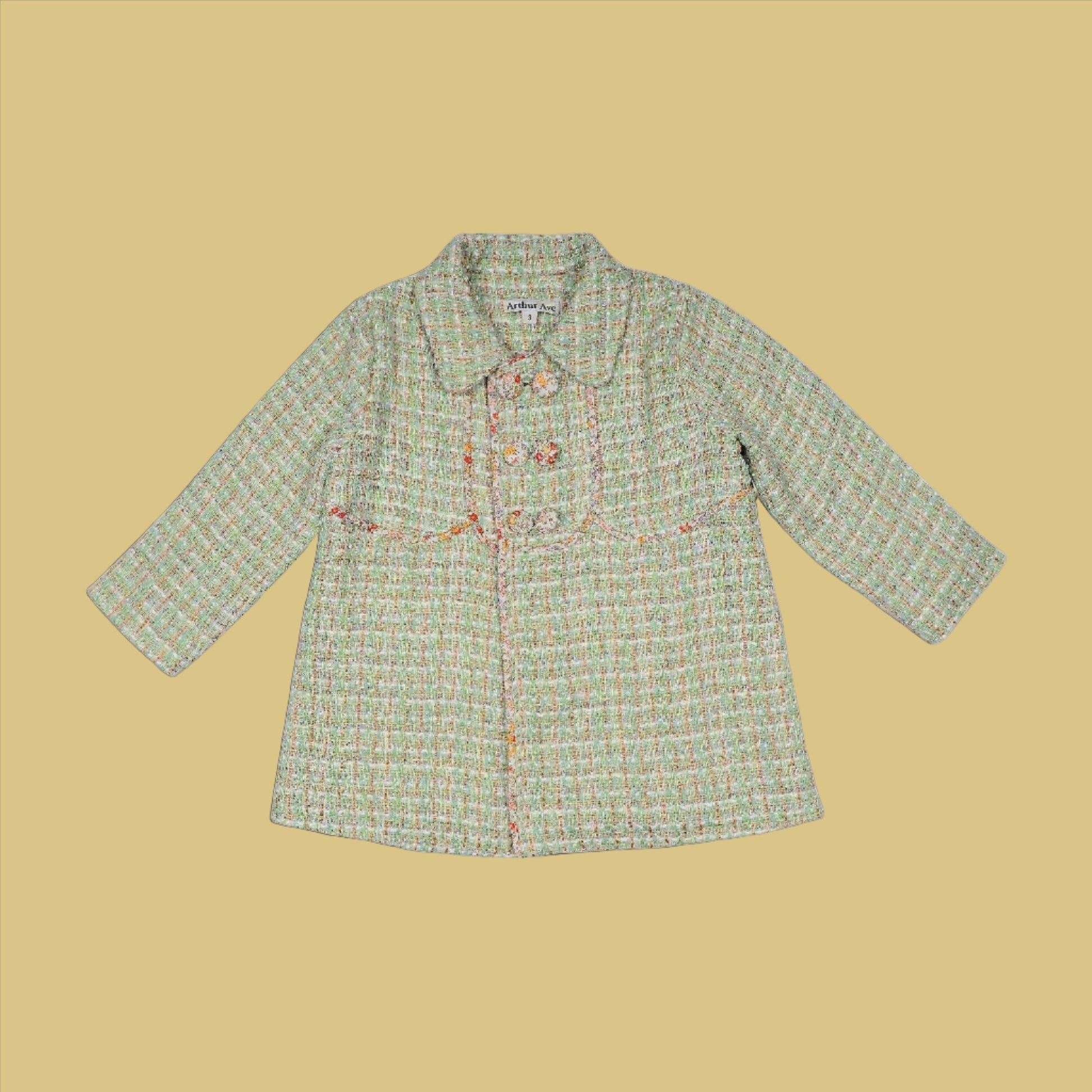 This adorable vintage inspired coat is from Arthur Ave's Winter Bloom Collection. In a mint tweed with gold thread running through on the outside, it is fully lined inside in an autumn toned floral pattern fabric. Completing the style is the double-breasted front which can be buttoned to either side with four gorgeous floral fabric covered buttons.